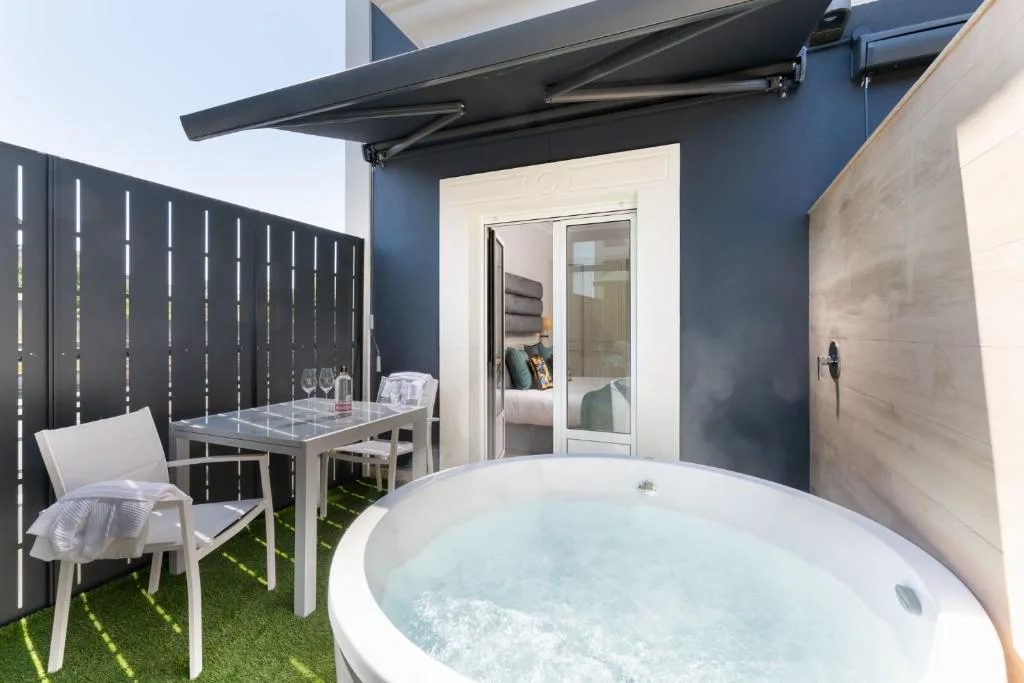 Terraza privada con jacuzzi redondo, mesa y sillas