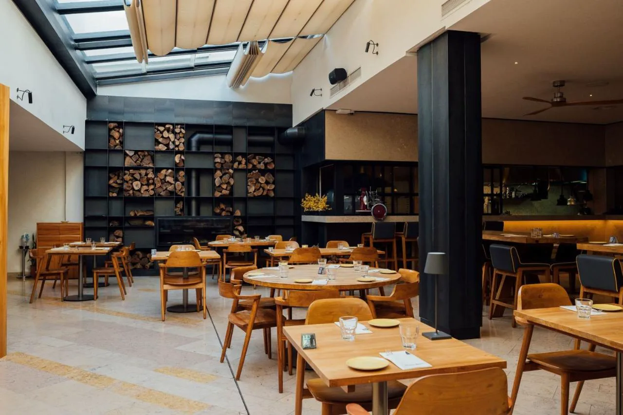 Restaurante de 3HB Faro con chimenea y leña decorativa
