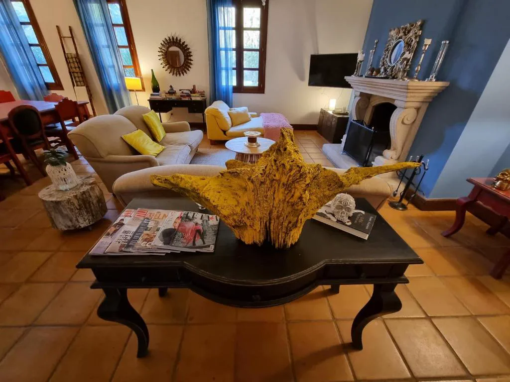 Salón con chimenea de piedra, pared azul y decoración ecléctica, Casa A Pedreira