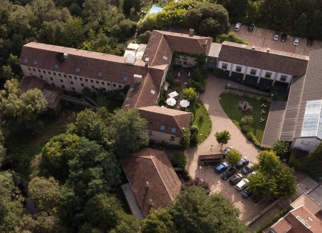 Vista aérea de A Quinta da Auga Hotel Spa Relais & Châteaux con su fachada de piedra centenaria y aparcamiento entre robles, Santiago de Compostela