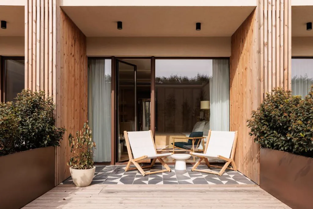 Terraza privada con tumbonas de madera y vegetación, Aethos Hotel Ericeira