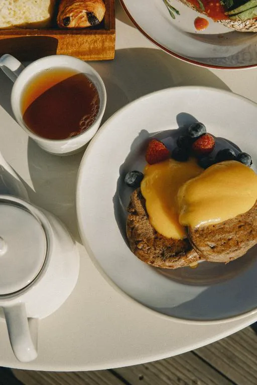 Desayuno con tostadas, frutos rojos y té en la terraza de Aethos Hotel Ericeira