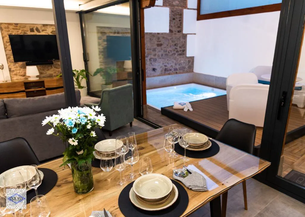 Salón con mesa preparada y ventanal sobre una piscina