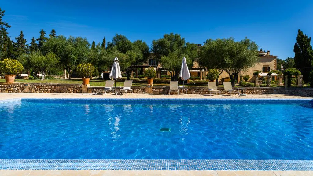 Piscina rodeada de olivos con vistas a la finca señorial, Agroturisme Son Cardaix, Artà, Mallorca