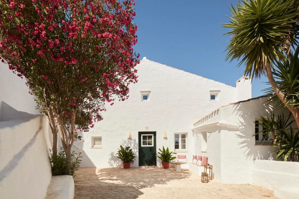 Fachada blanca tradicional menorquina con adelfas en flor, Agroturismo Rafal Rubí