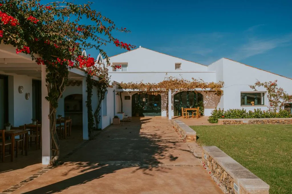 Entrada de la finca bajo un árbol de buganvilla roja en flor, Agroturismo Son Vives
