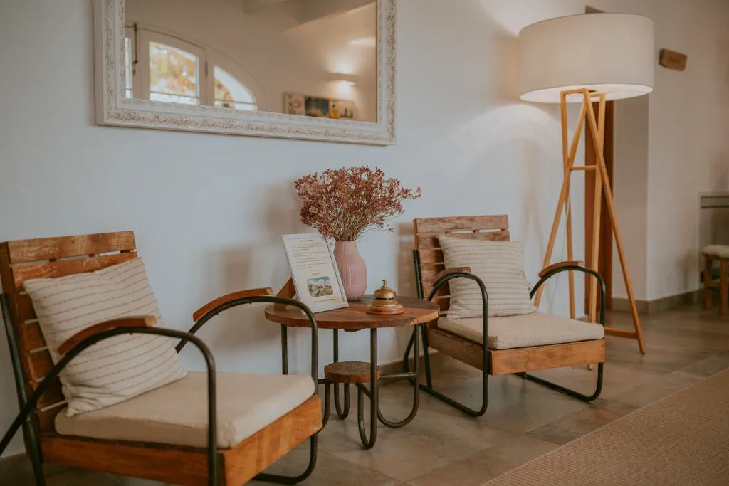 Zona de estar con sillones de madera y cojines de rayas junto a una lámpara de pie, Agroturismo Son Vives