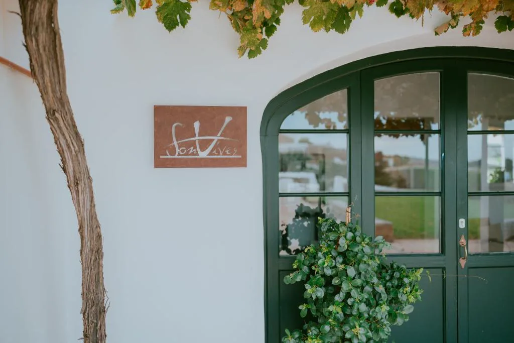 Recepción con estanterías de madera antigua y suelo de piedra, Agroturismo Son Vives
