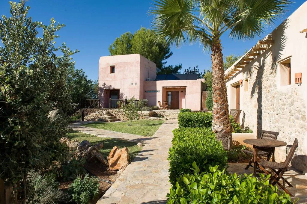 Casas de arquitectura tradicional ibicenca en tonos rosados entre jardines, Agroturismo Xarc