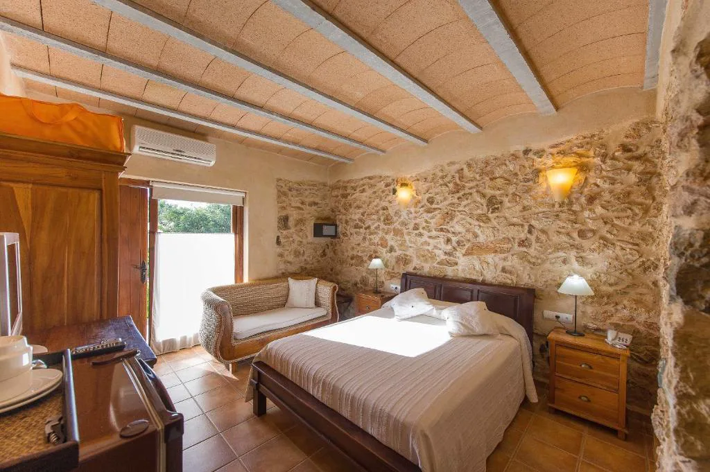Dormitorio con techo abovedado y pared de piedra vista, Agroturismo Xarc