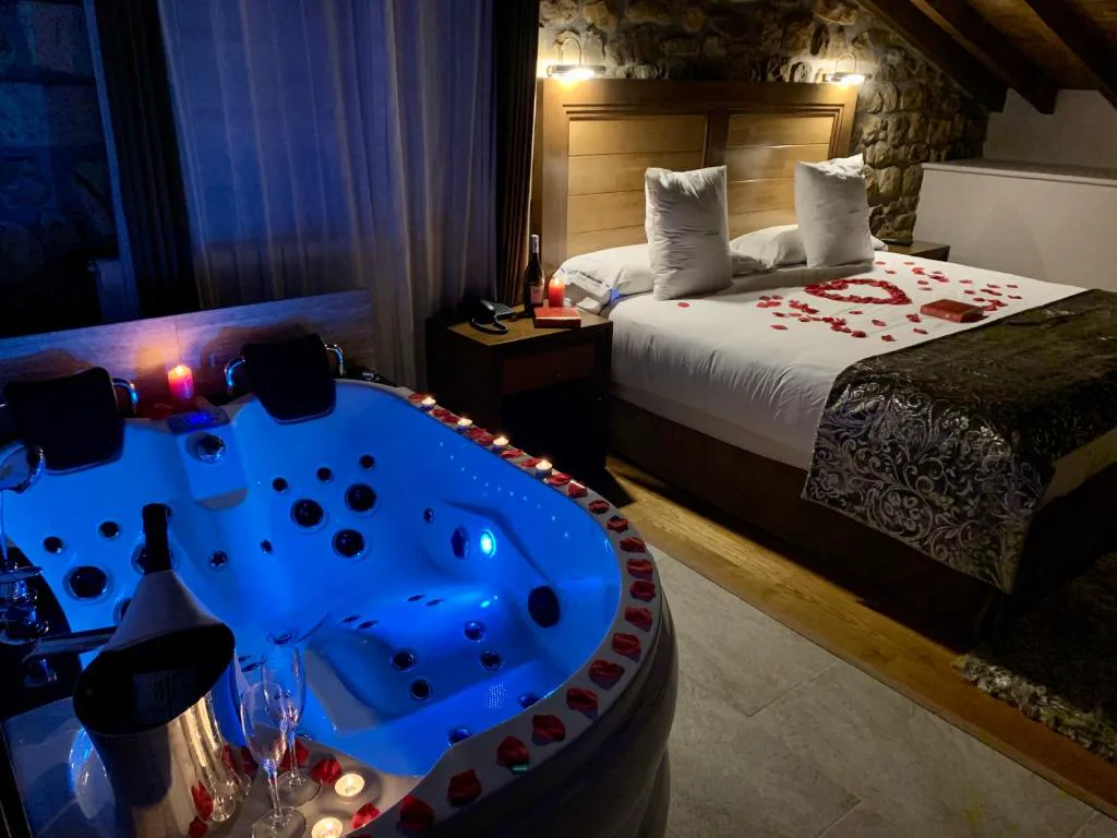 Habitación con jacuzzi iluminado de azul junto a la cama