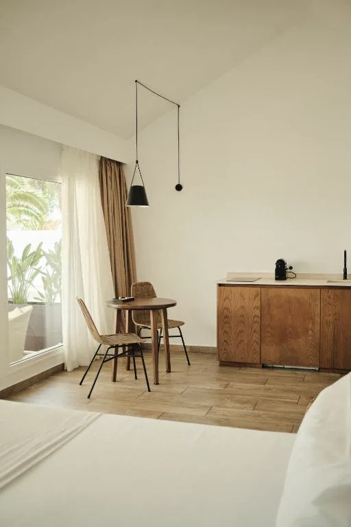 Suite con mesa redonda y techos altos junto a la puerta al jardín, Alava Suites