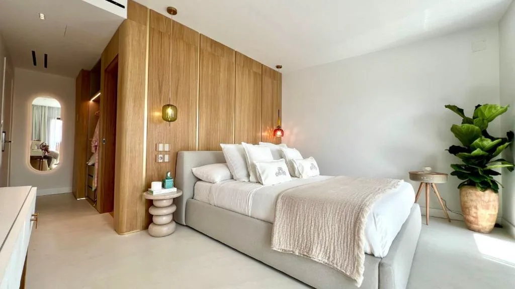 Habitación con cabecero de madera, plantas y mesa auxiliar de mármol, Aldea Calma