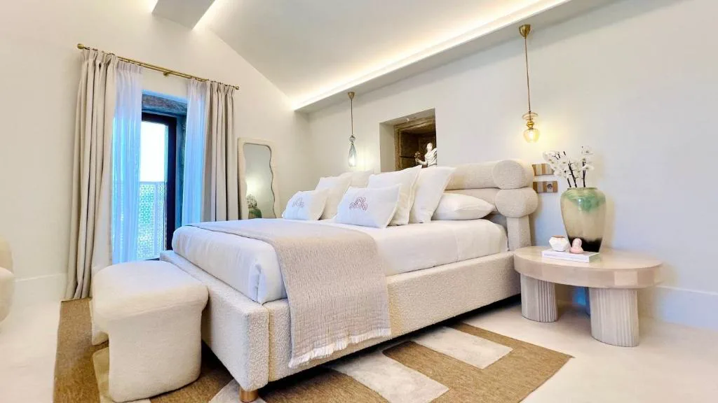 Habitación con cabecero curvo y luces cálidas integradas, Aldea Calma
