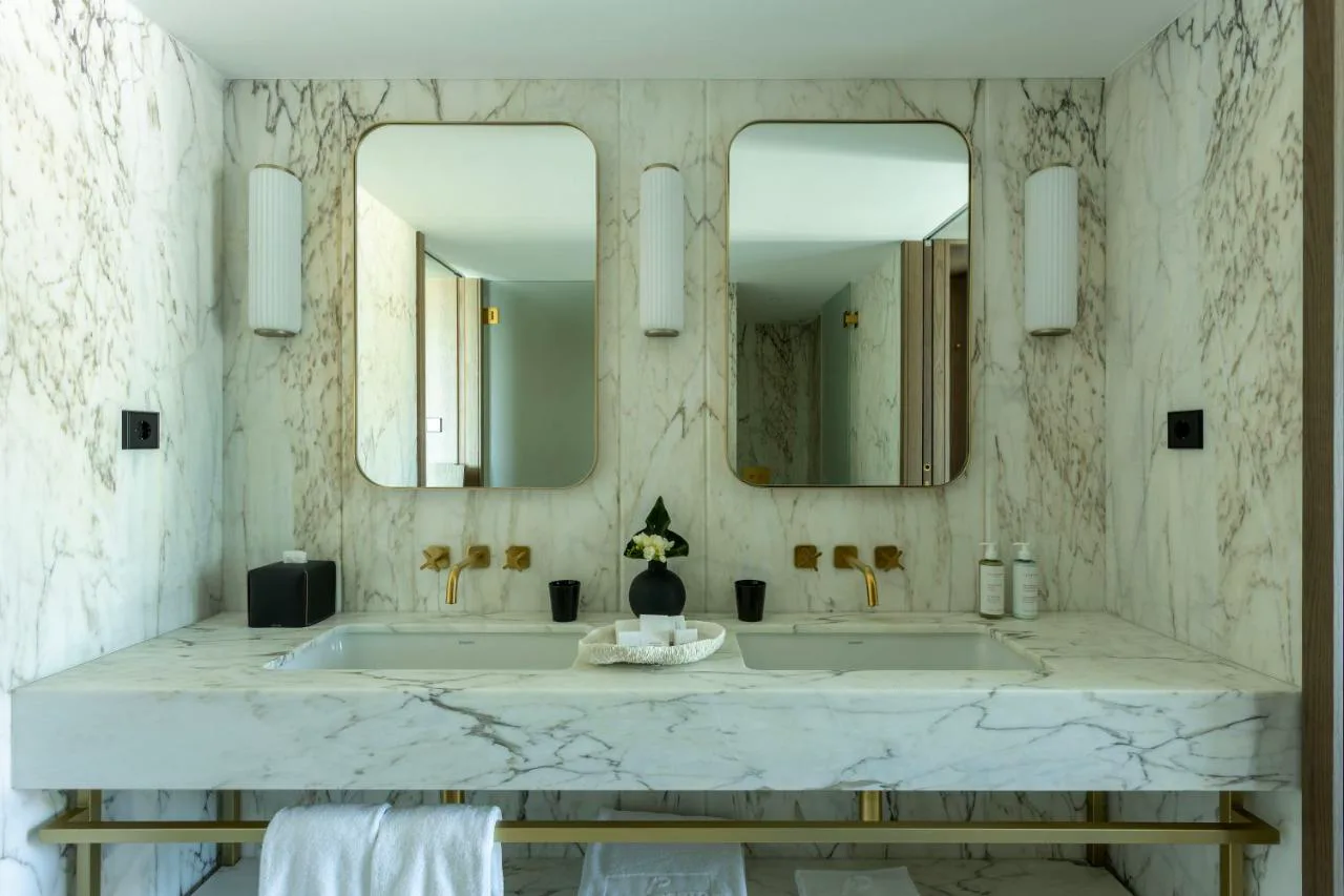 Baño de mármol con doble lavabo en Altis Porto Hotel