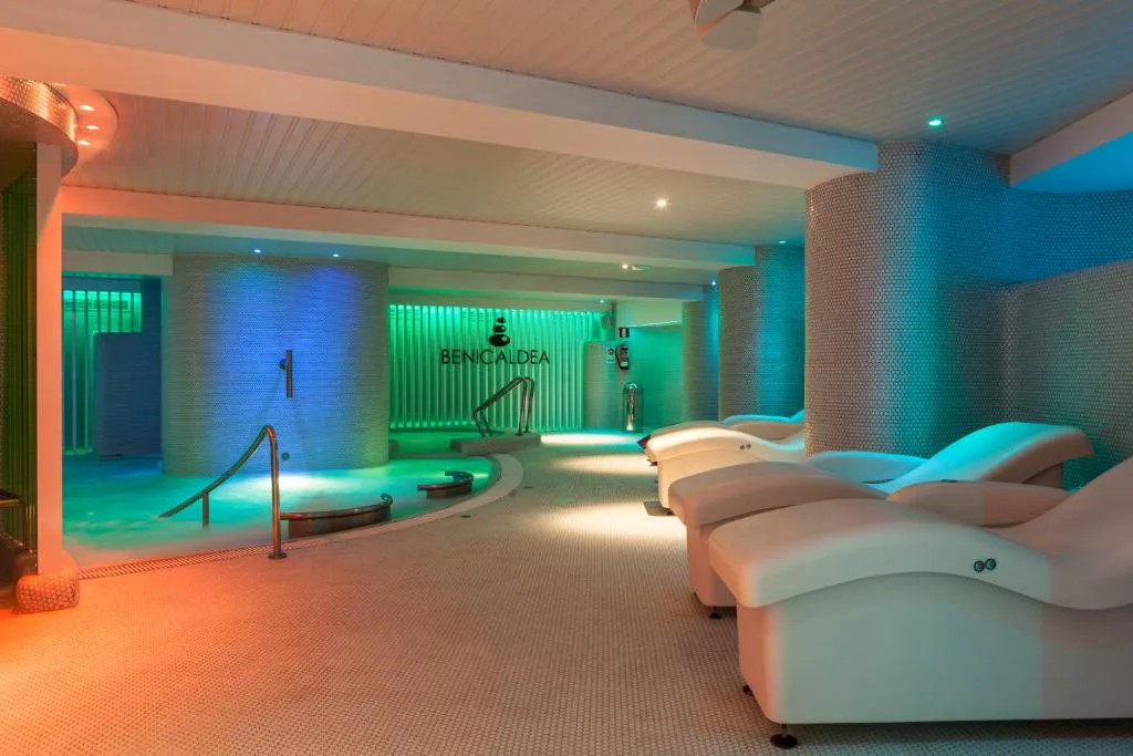 Sala de spa con piscina y luz verde y naranja