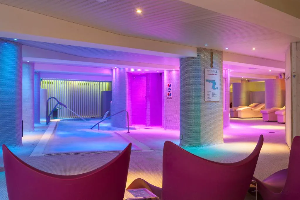 Zona de spa con luces de colores y tumbonas de relax