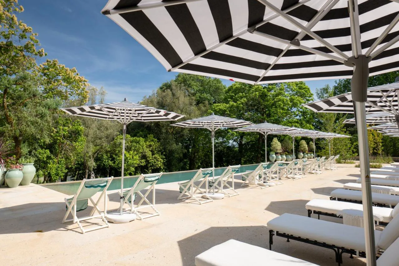 Terraza de la piscina infinita de Amoure Hotel entre árboles