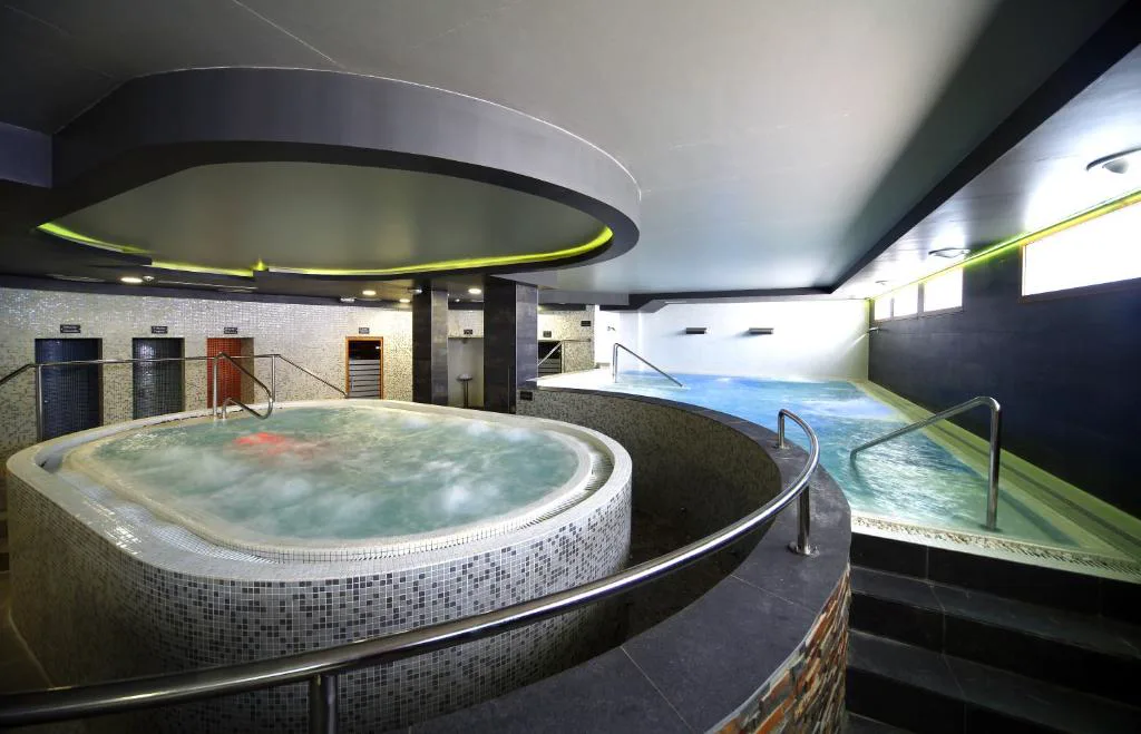 Jacuzzi circular en una sala de spa con luz tenue