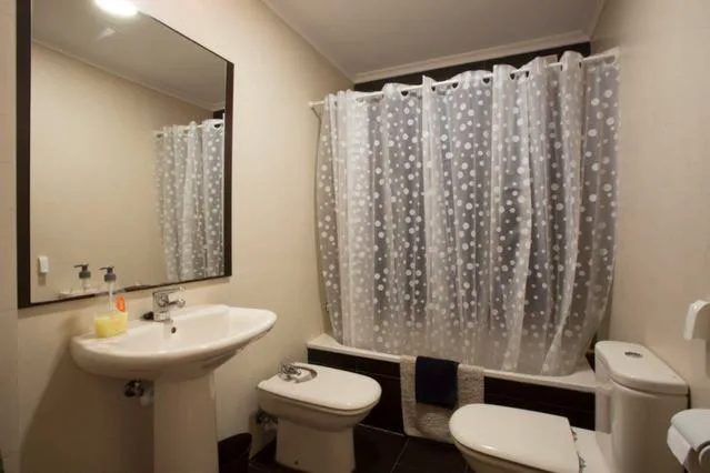 Baño con ducha y toallas en estantería