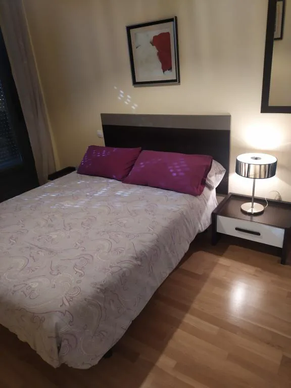 Dormitorio con cama doble y cabecero oscuro