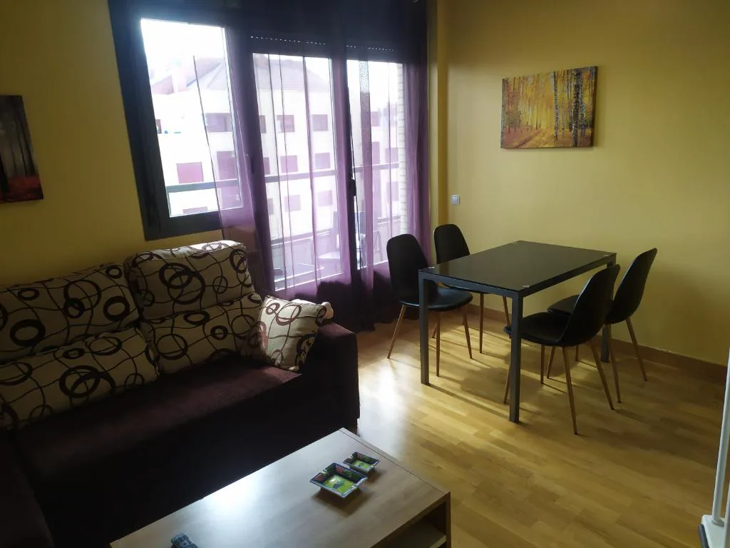 Salón con sofá marrón y comedor