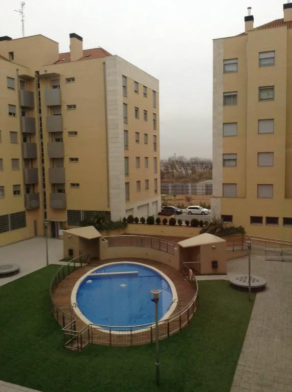 Piscina comunitaria azul vista desde un edificio de apartamentos