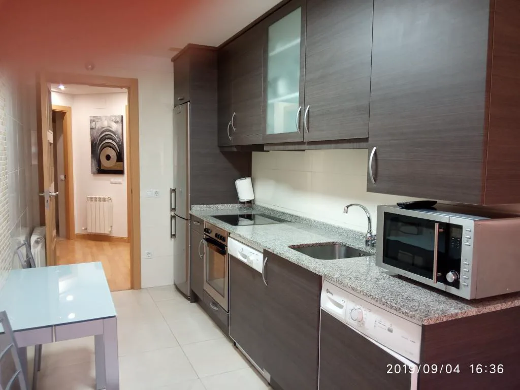 Cocina con muebles oscuros y encimera
