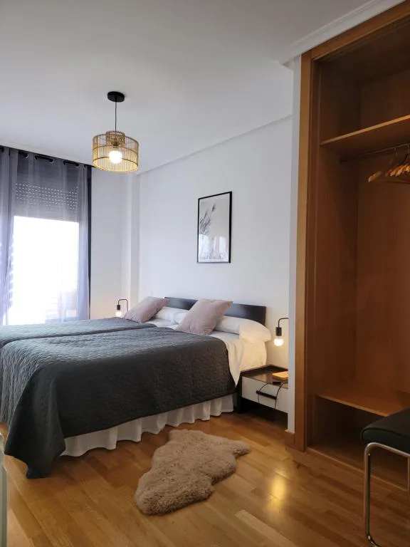 Dormitorio con cama doble y mesilla de madera