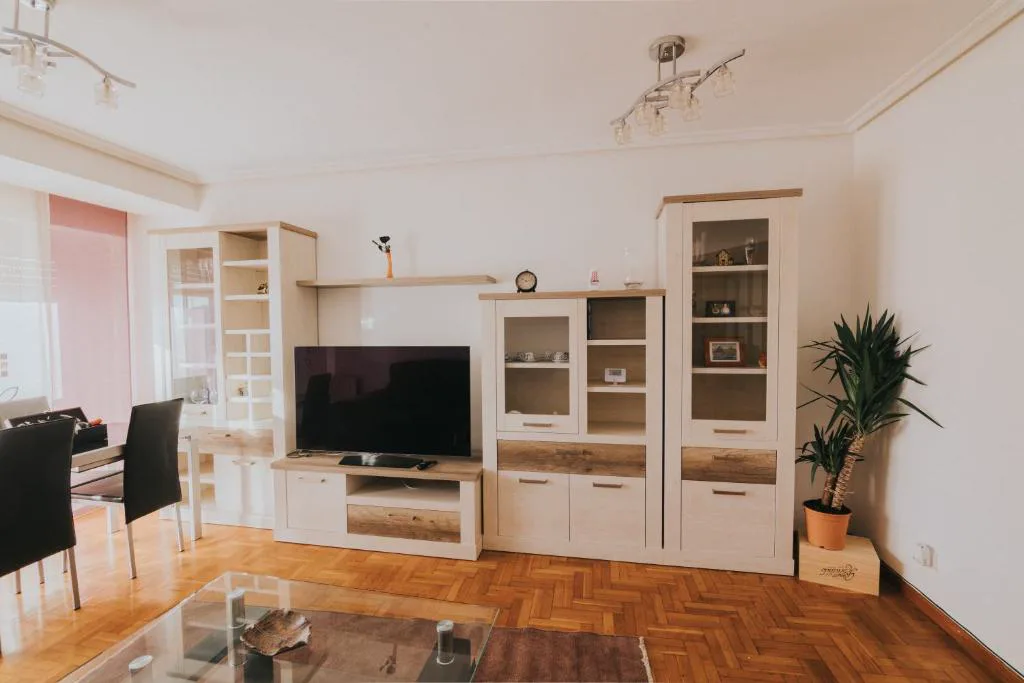 Salón con sofás blancos y dos ventanales