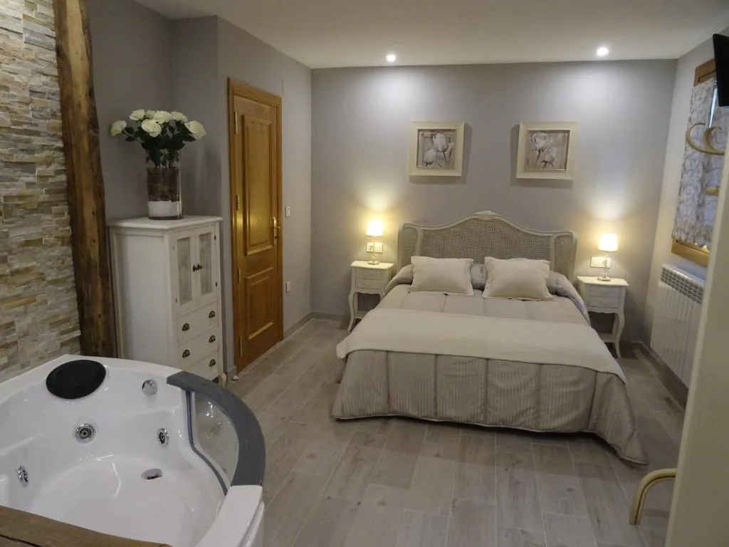 Habitación con jacuzzi junto a la cama