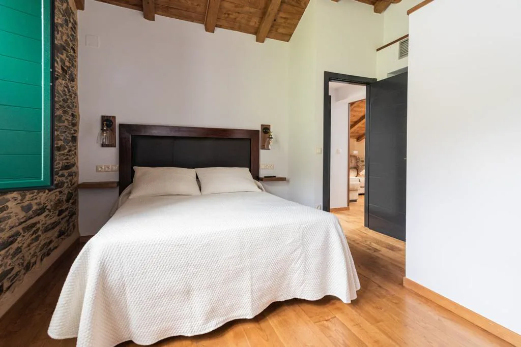 Dormitorio con cabecero oscuro y luz cálida