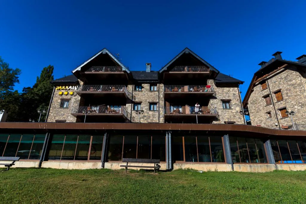 Fachada de piedra y madera del aparthotel entre montañas
