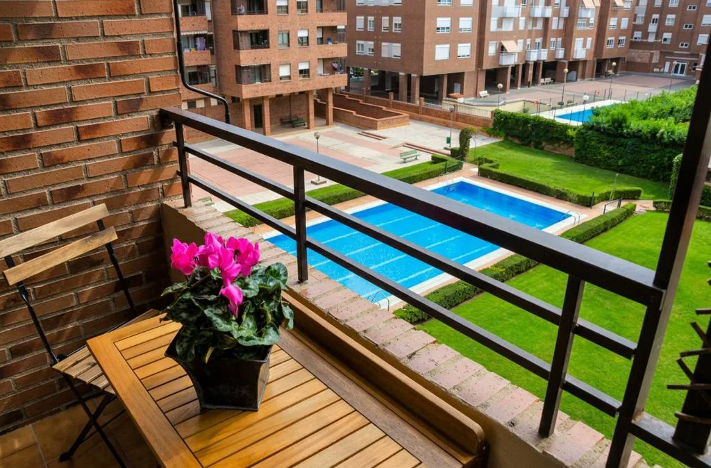 Piscinas comunitarias con césped y balcón con flores