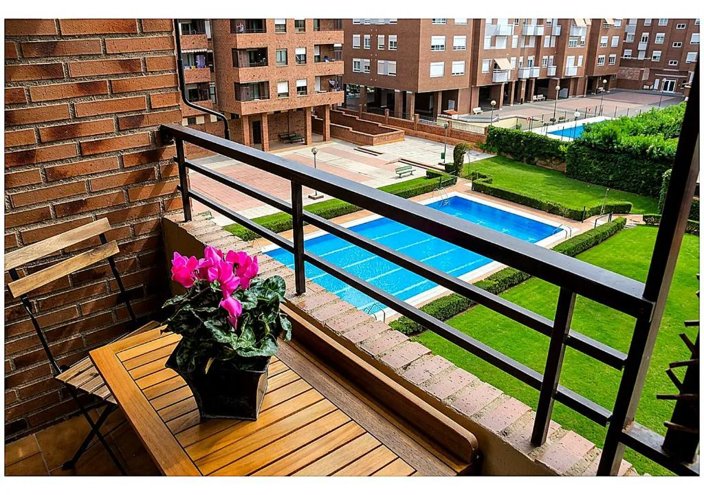 Piscina azul vista desde el balcón del apartamento