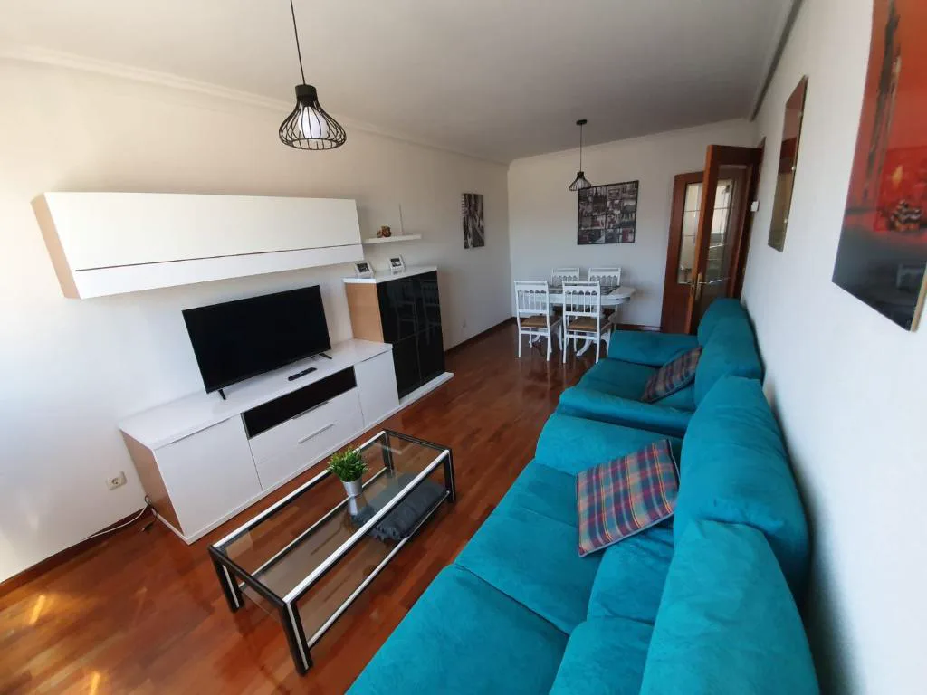 Salón con sofá azul y televisión
