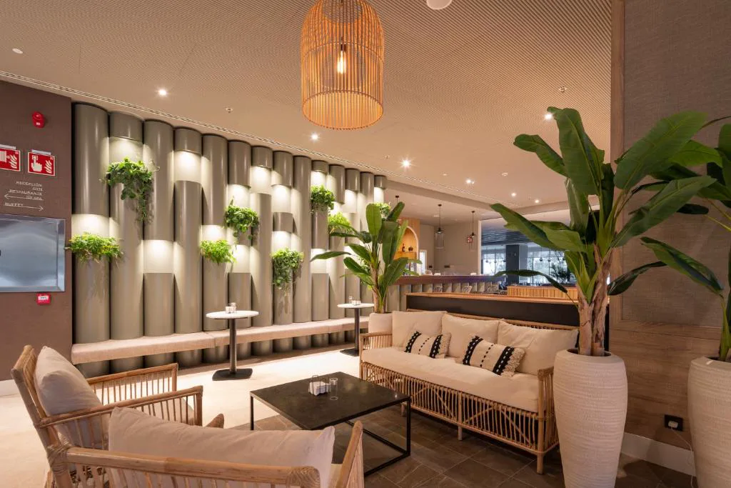 Zona de estar del lobby con sofás y plantas junto a la recepción, Attica21 Vigo