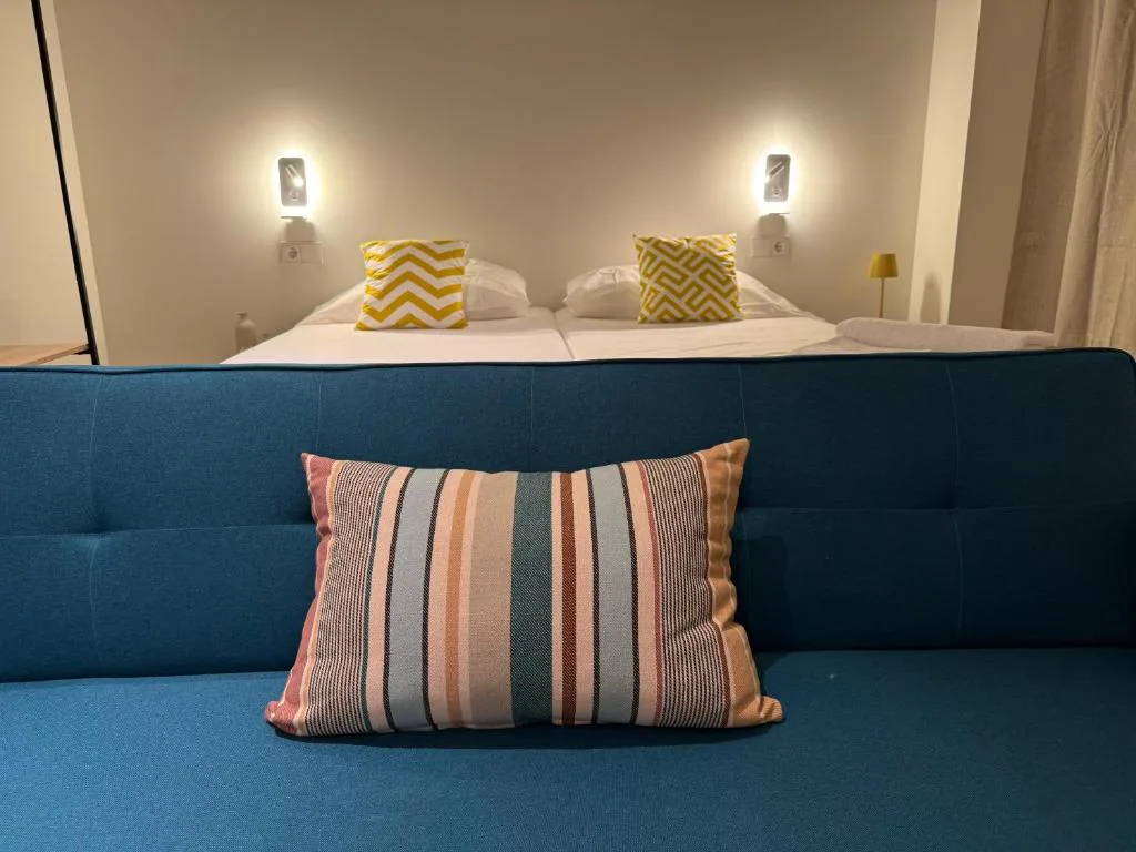 Dormitorio con cabecero azul y cojines amarillos
