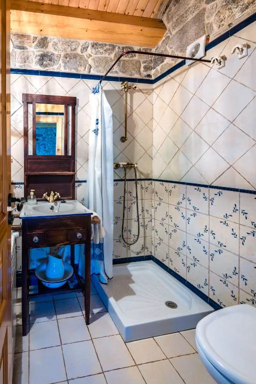 Baño de azulejo azul y blanco con lavabo de mueble antiguo, A Avoa María