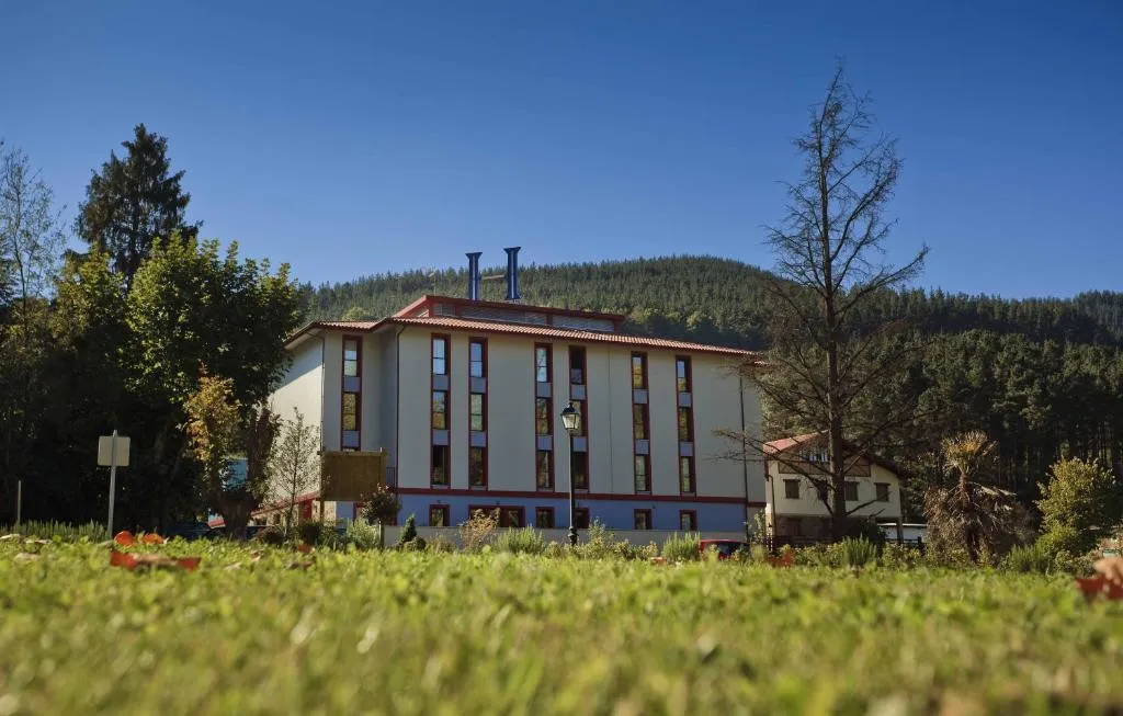 Fachada del Balneario de Areatza rodeada de monte y vegetación, Vizcaya
