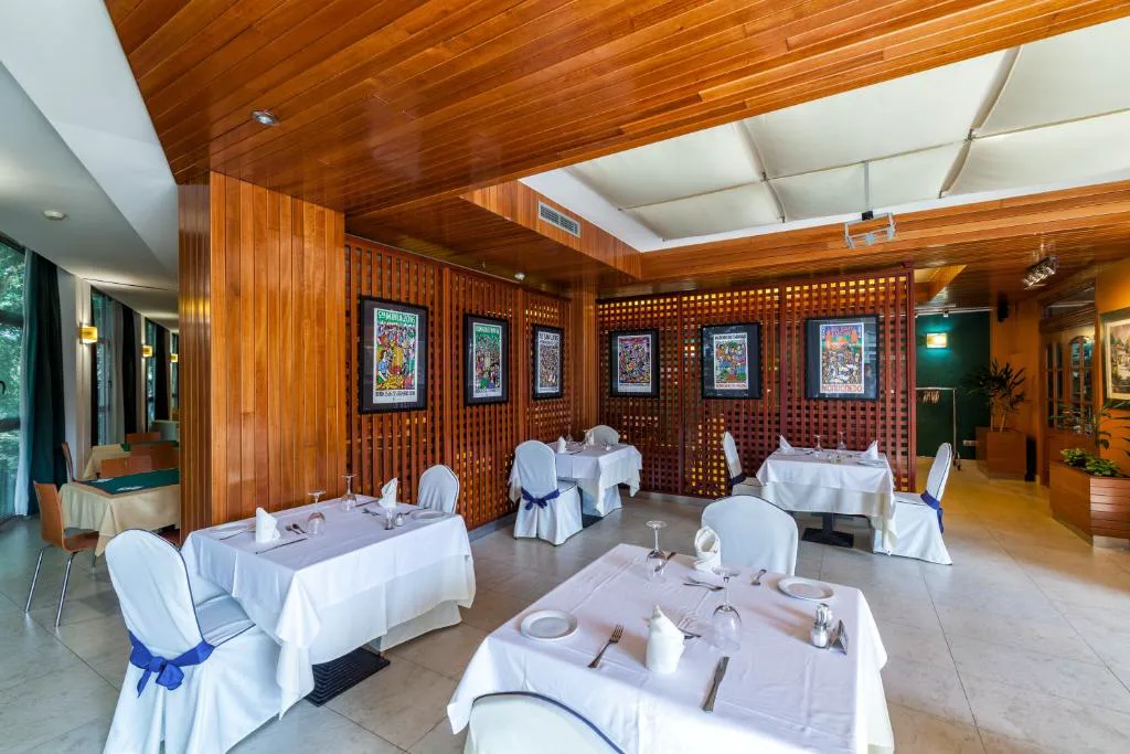 Comedor con techo de madera y mesas vestidas de blanco, Hotel Balneario de Compostela