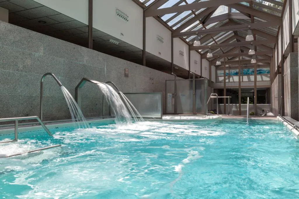 Piscina con cascadas de agua bajo techo acristalado, Hotel Balneario de Compostela