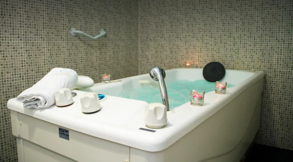 Bañera de hidromasaje / jacuzzi con velas encendidas en el spa del Hotel Balneario Río Pambre