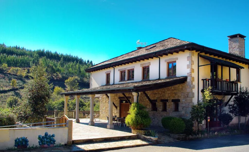 Fachada tradicional gallega de piedra del Hotel Balneario Río Pambre entre robles, Palas de Rei