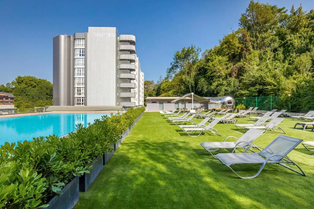 Jardín con tumbonas junto a la piscina