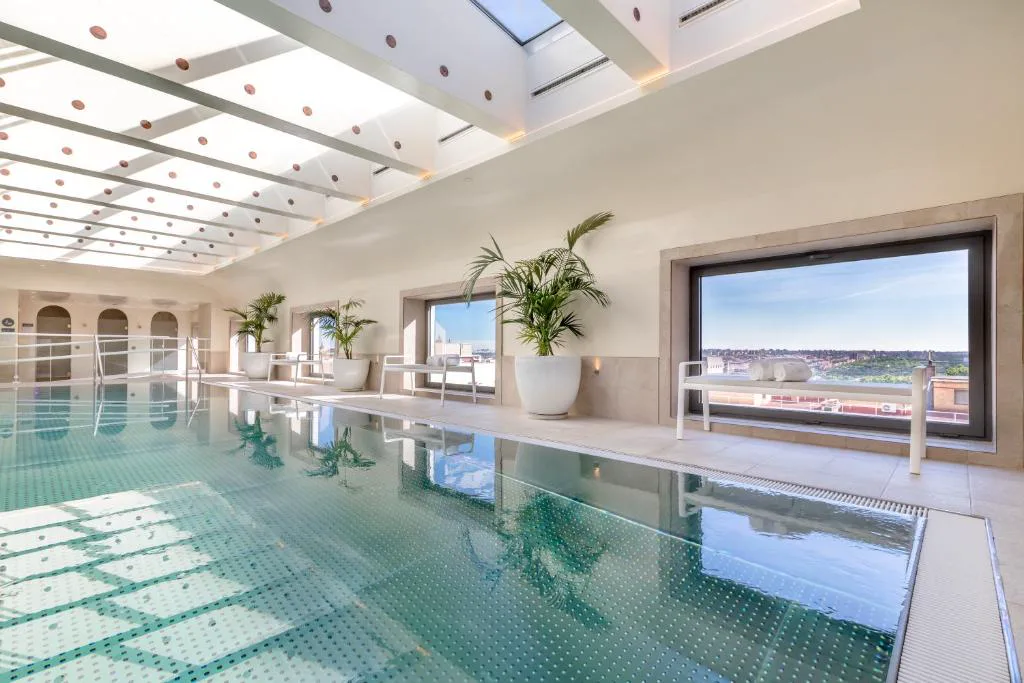 Piscina de azotea con escalones blancos frente a un edificio de Madrid