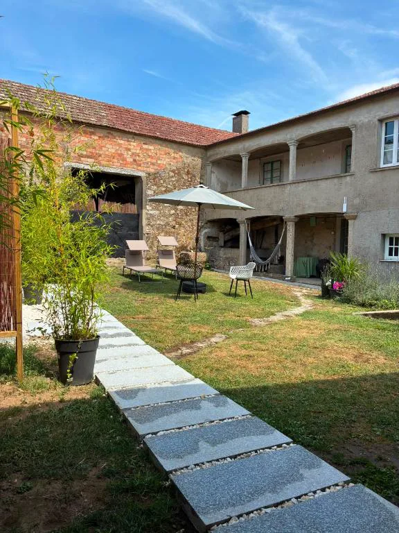Fachada de piedra tradicional gallega con jardín, hamaca y tumbonas, Bella Casa Araujo