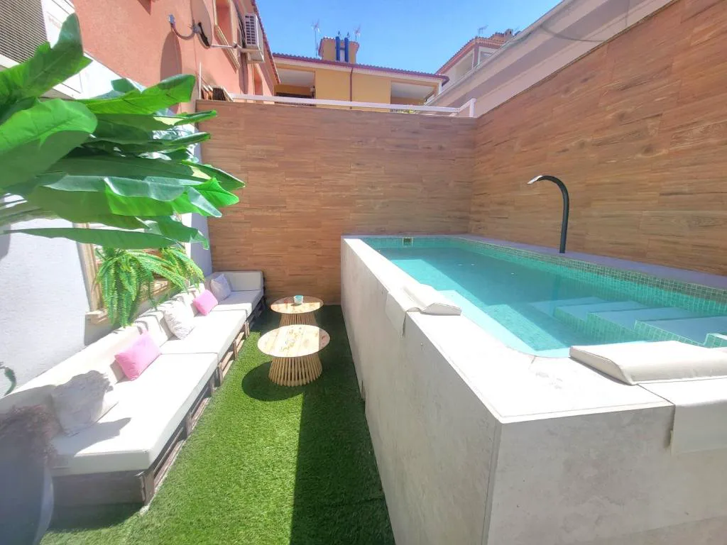 Piscina elevada con luz azul en un patio con césped