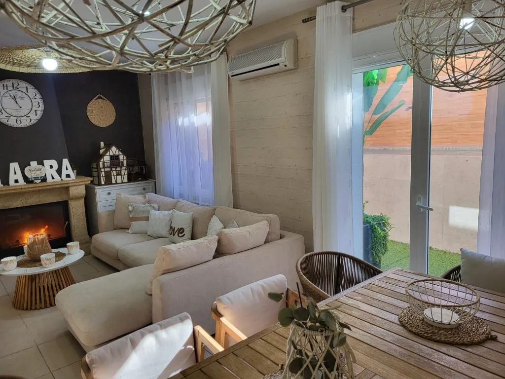 Salón con chimenea y sofás junto a un ventanal