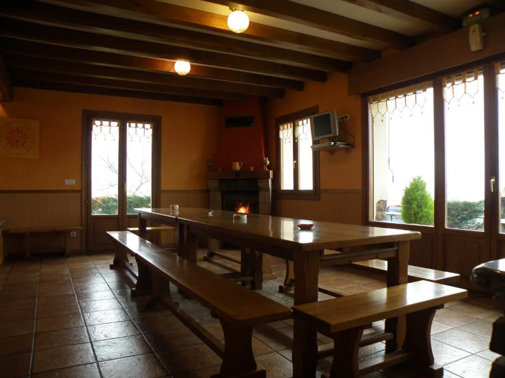 Comedor con chimenea encendida y vigas de madera